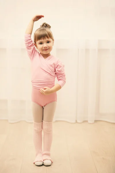 Pequena menina bonito em colete rosa fazendo novo movimento de balé no estúdio de dança — Fotografia de Stock