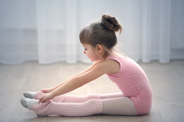 Schattig meisje in roze leotard maken nieuwe ballet beweging op dansstudio — Stockfoto