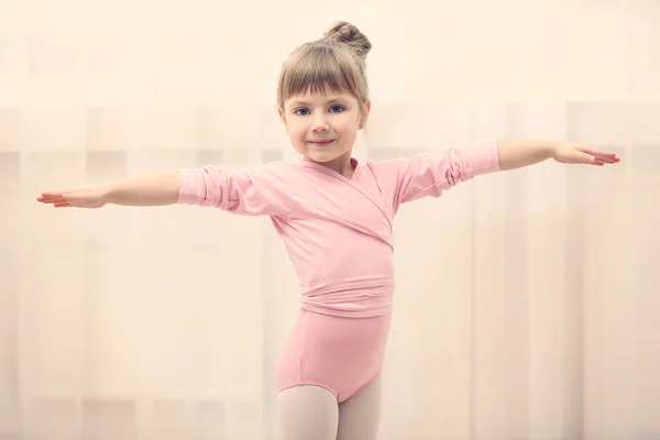 Schattig meisje in roze leotard maken nieuwe ballet beweging op dansstudio — Stockfoto