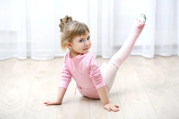 Niña linda en maillot rosa haciendo un nuevo movimiento de ballet en el estudio de danza — Foto de Stock