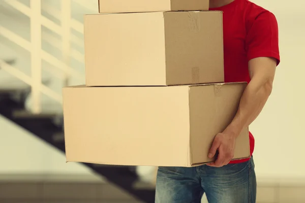Чоловік тримає купу картонних коробок — стокове фото