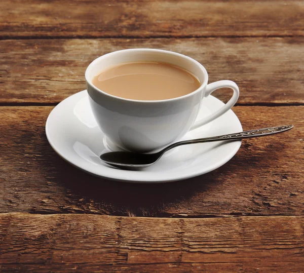 Taza de té de porcelana con leche sobre fondo de madera — Foto de Stock