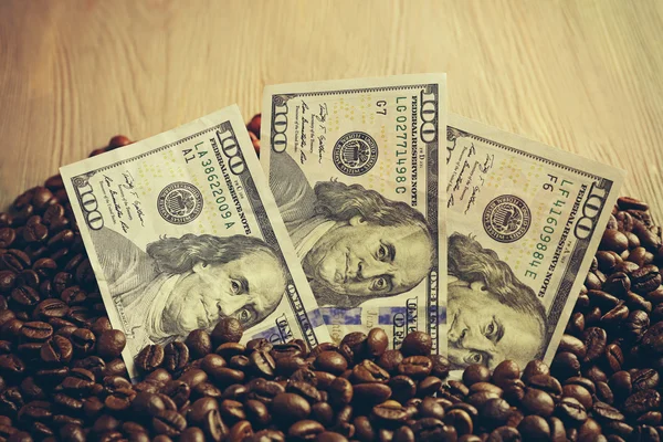 Granos de café y billetes en dólares —  Fotos de Stock