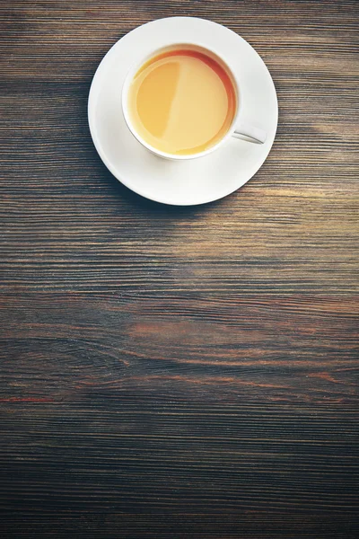 Porcelanowa filiżanka herbaty z mlekiem na drewniane tła — Zdjęcie stockowe