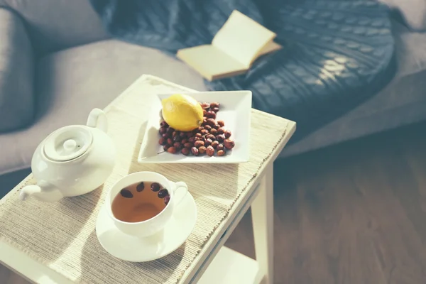 Rosa mosqueta y té de limón en la mesa en la habitación — Foto de Stock