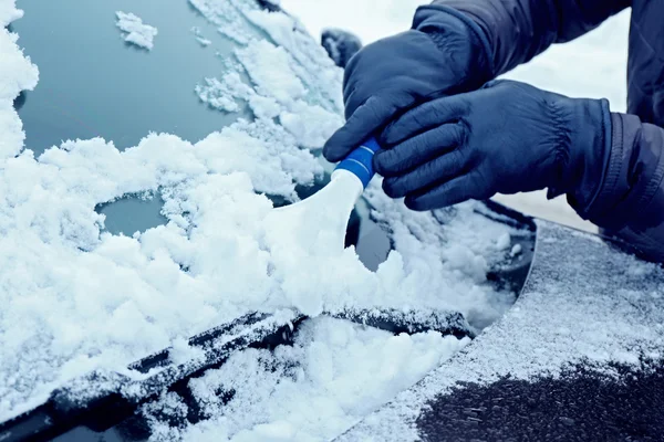 Removendo a neve do pára-brisas do carro — Fotografia de Stock