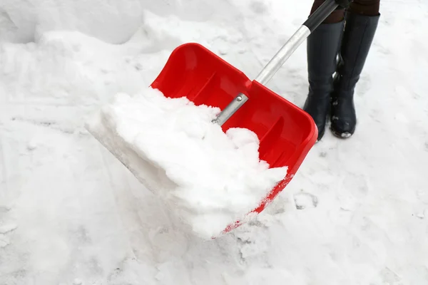 Женщина убирает снег — стоковое фото