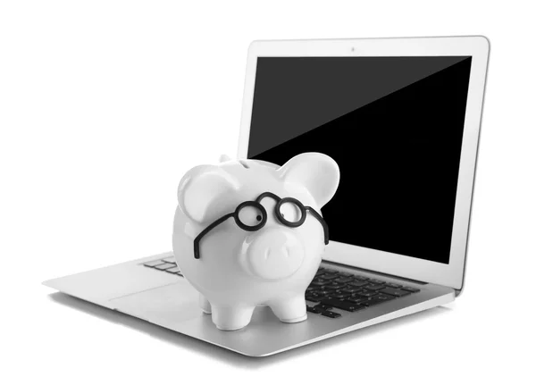 Piggy banco em óculos no laptop — Fotografia de Stock