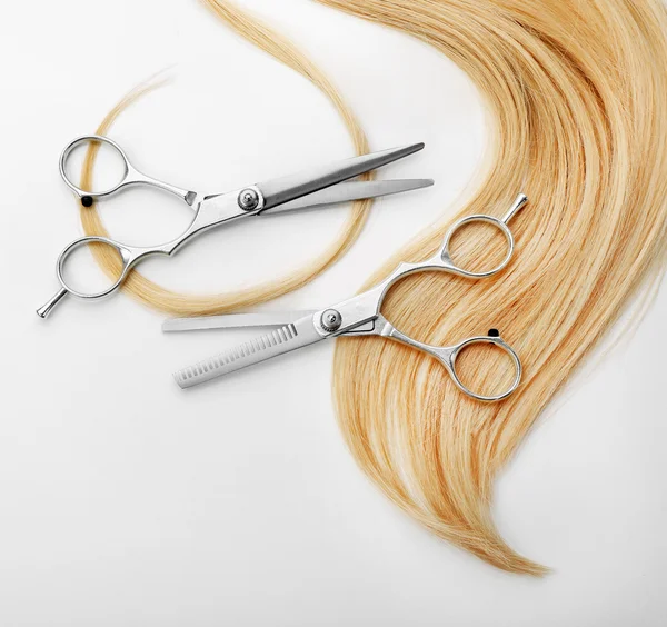 Scissors with strand of blonde hair — Stock Photo, Image
