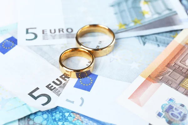Golden wedding rings on banknotes — Stock Photo, Image
