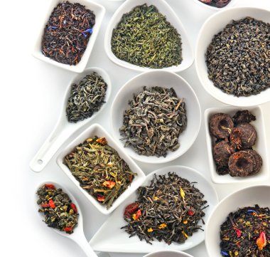 Kase ve üzerinde beyaz izole kaşık kuru çay çeşitli