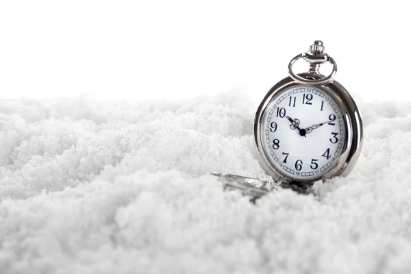 Карманные часы над белым снегом — стоковое фото