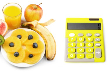 Hesap makinesi üzerinde beyaz izole meyve suyu ve meyve ile