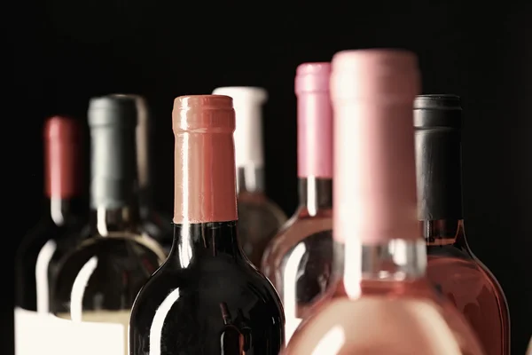 Diferentes cuellos de botella de vino sobre fondo oscuro — Foto de Stock