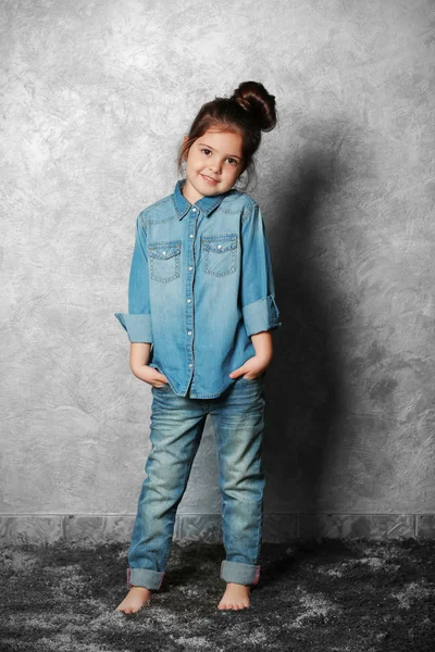 Porträtt av lilla mode kid flicka på grå vägg bakgrund — Stockfoto