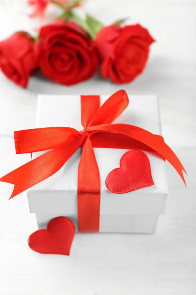 Caja de regalo, flores de rosas y corazones decorativos sobre fondo de madera claro —  Fotos de Stock