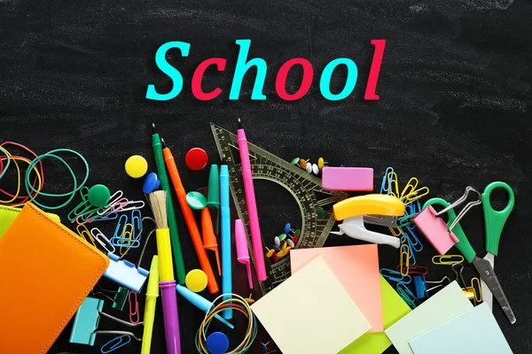 Kleurrijke briefpapier op schoolbord achtergrond — Stockfoto