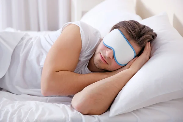 Joven durmiendo con los ojos vendados en la cama en casa — Foto de Stock