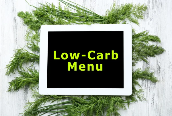 Menú bajo en carbohidratos en la pantalla de la tableta PC con hierbas frescas sobre fondo de madera — Foto de Stock