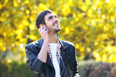 Adam bir parkta müzik dinlemek 