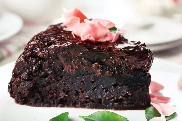 Pezzo di torta al cioccolato decorato con fiori su tavolo di legno bianco — Foto Stock