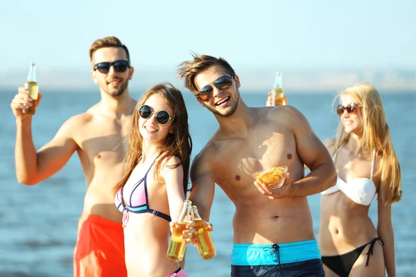 Des amis heureux buvant de la bière à la plage — Photo