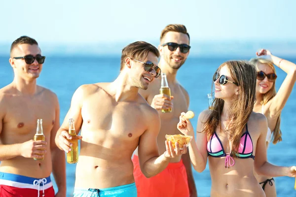 Happy friends drinking beer at beach — Stock Photo, Image