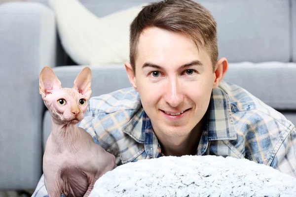 Bonito homem está com gato no chão — Fotografia de Stock