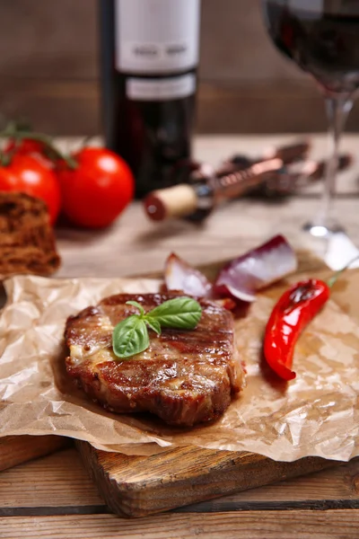 Roasted beef fillet and vegetables on cutting board, on wooden background — Stock Photo, Image