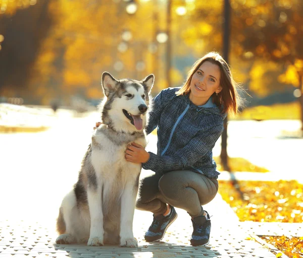 Žena chůze se psem v parku — Stock fotografie