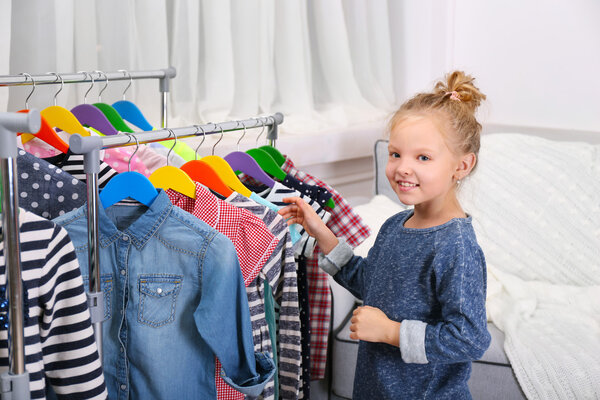 Маленькая девочка примеряет платье
