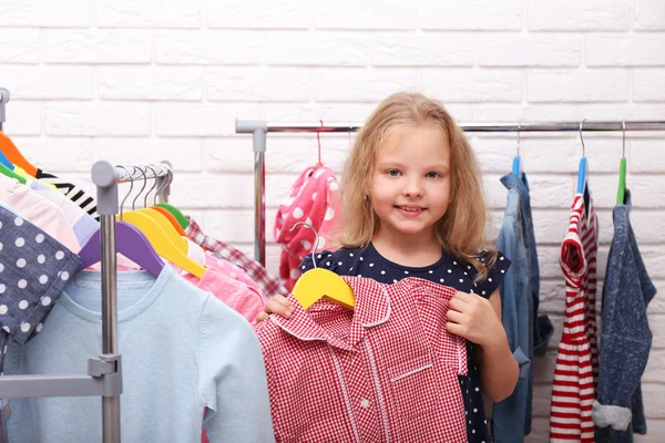 Liten flicka försöker på klänning — Stockfoto