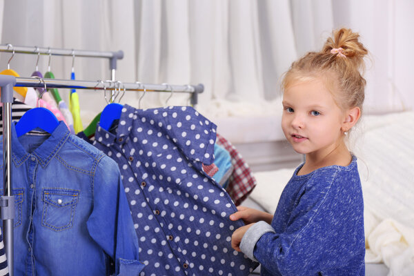 Маленькая девочка примеряет платье
