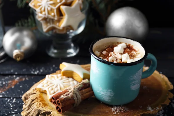 Mugg av heta cacao med marshmallow och cookies på svart bord — Stockfoto