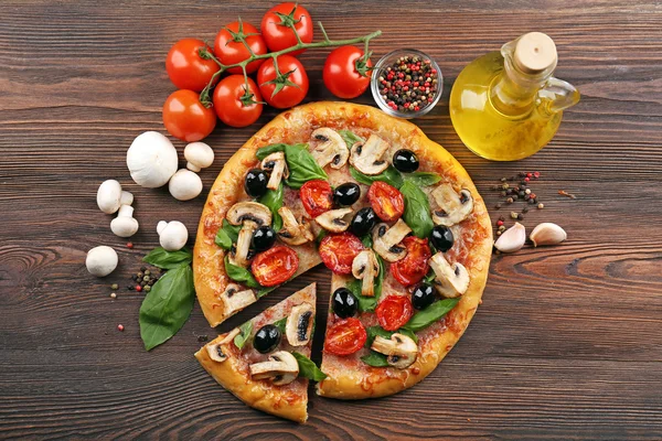 Sebze ile lezzetli lezzetli pizza ahşap masanın üzerine dilimlenmiş — Stok fotoğraf