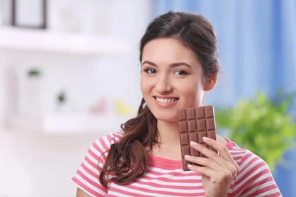 Retrato de bela jovem morena com chocolate no quarto, close-up — Fotografia de Stock