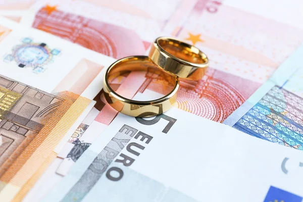 Golden wedding rings on banknotes — Stock Photo, Image