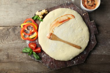 Taze hamur pizza domates ile hazırlanan ve biber ahşap bir tahta üzerine dilimlenmiş, yakın çekim