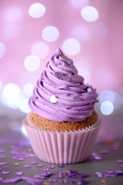 Cupcake mor krem bir glitter arka plan üzerinde buzlanma ile yakın çekim