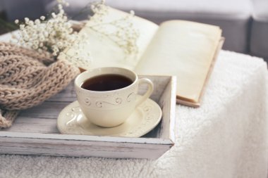 Fincan çay ve odada kahve masada açık kitap kompozisyon yakın çekim