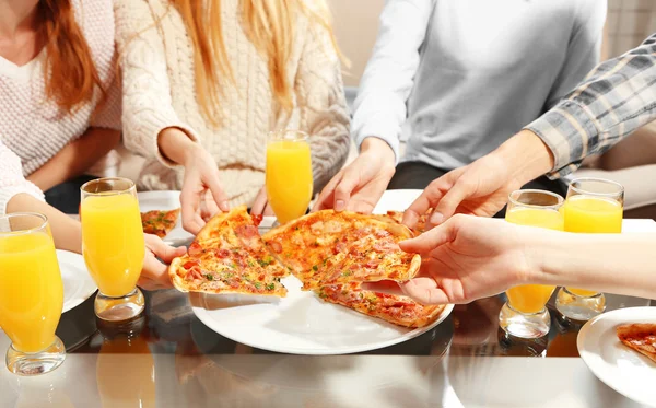 Amigos manos sosteniendo pizza caliente, de cerca —  Fotos de Stock