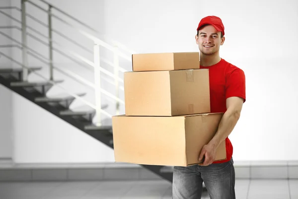 Hombre sosteniendo pila de cajas de cartón — Foto de Stock