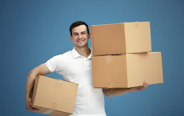 Hombre sosteniendo pila de cajas de cartón — Foto de Stock