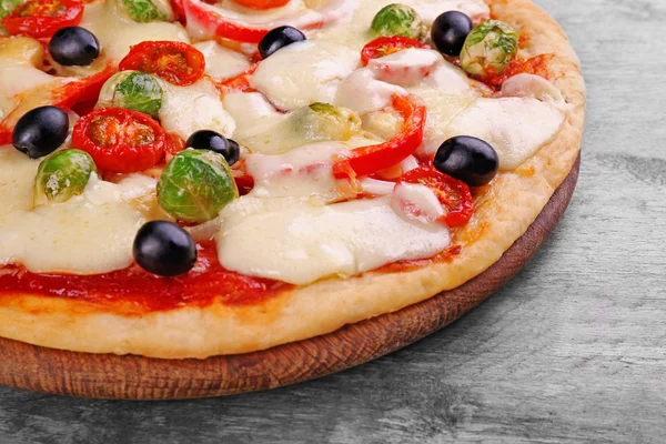 Delicious pizza with cheese and vegetables on wooden table closeup — Stock Photo, Image