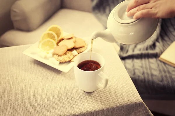 Žena, nalil čaj do hrnku od konvice — Stock fotografie