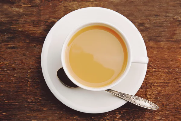 Taza de té de porcelana con leche sobre fondo de madera — Foto de Stock