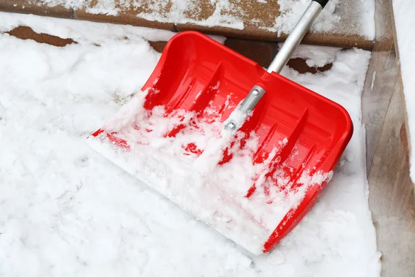Rote Schaufel zur Schneeräumung neben Treppen — Stockfoto