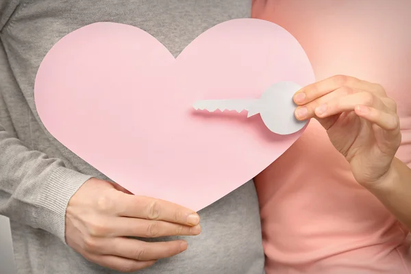 Couple holding paper heart and key — Stock Photo, Image