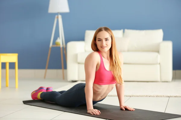 Sportswoman doing exercises on a mat — Stock Photo, Image