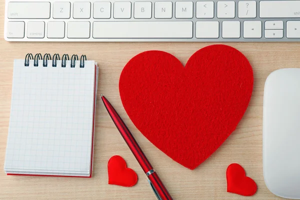 Computerrandapparatuur met rode hartjes, pen en notitieboekje — Stockfoto